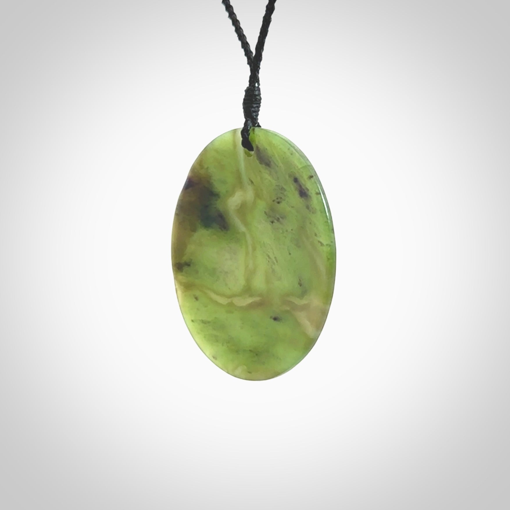 Hand carved New Zealand Totoweka Jade disc pendant by Ric Moor. Provided with black adjustable cord. Free worldwide delivery. One only pendant.