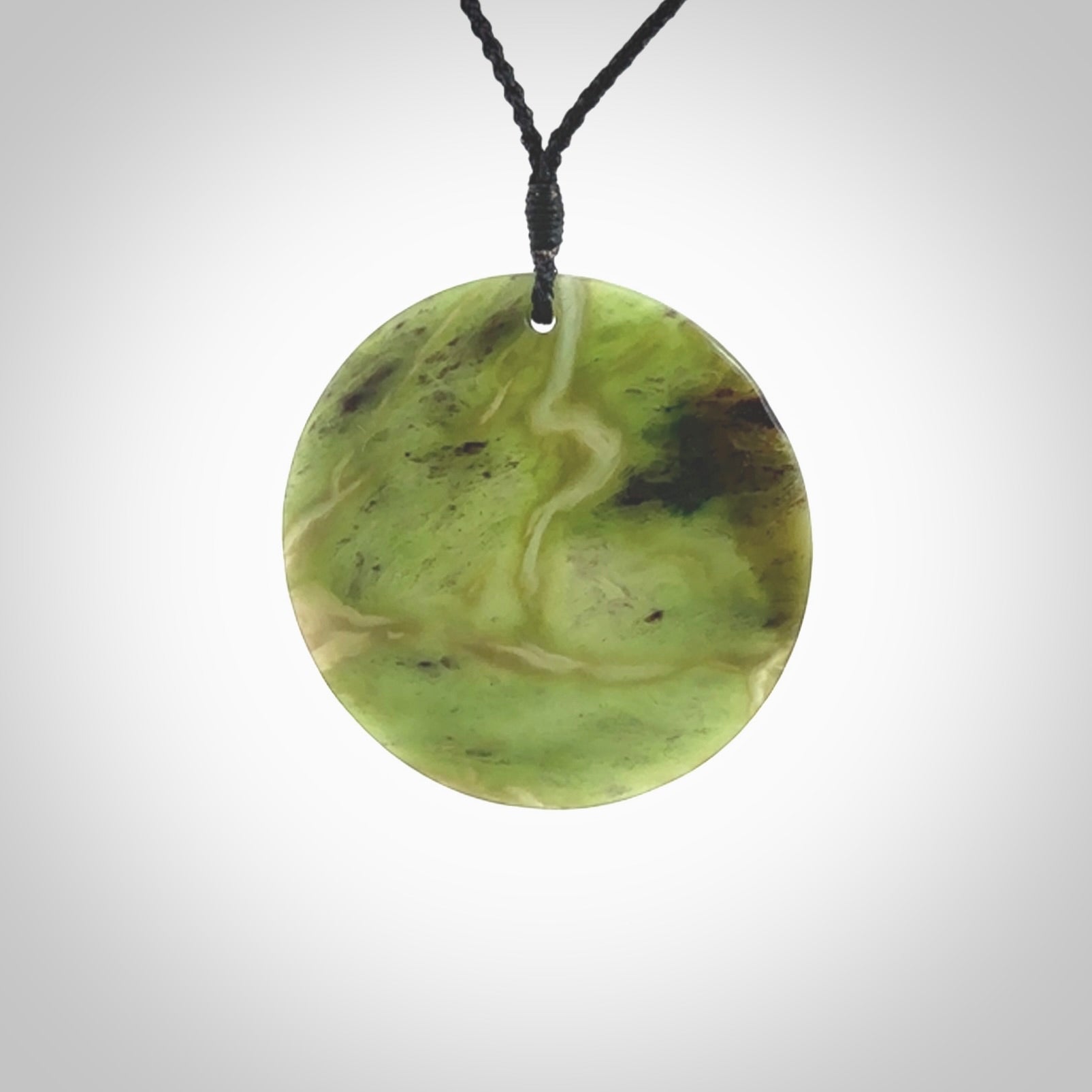 Hand carved New Zealand Totoweka Jade disc pendant by Ric Moor. Provided with black adjustable cord. Free worldwide delivery. One only pendant.