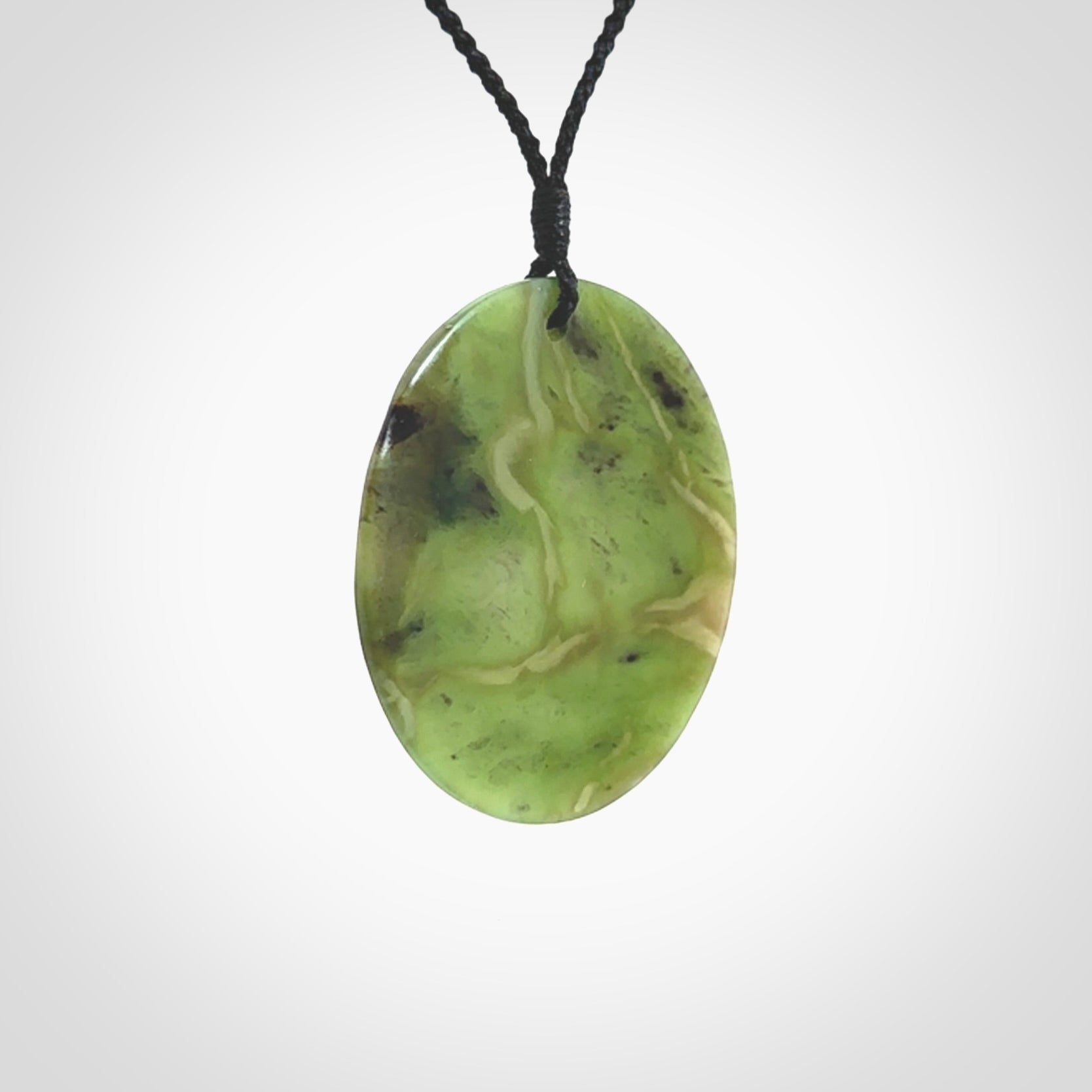 Hand carved New Zealand Totoweka Jade disc pendant by Ric Moor. Provided with black adjustable cord. Free worldwide delivery. One only pendant.