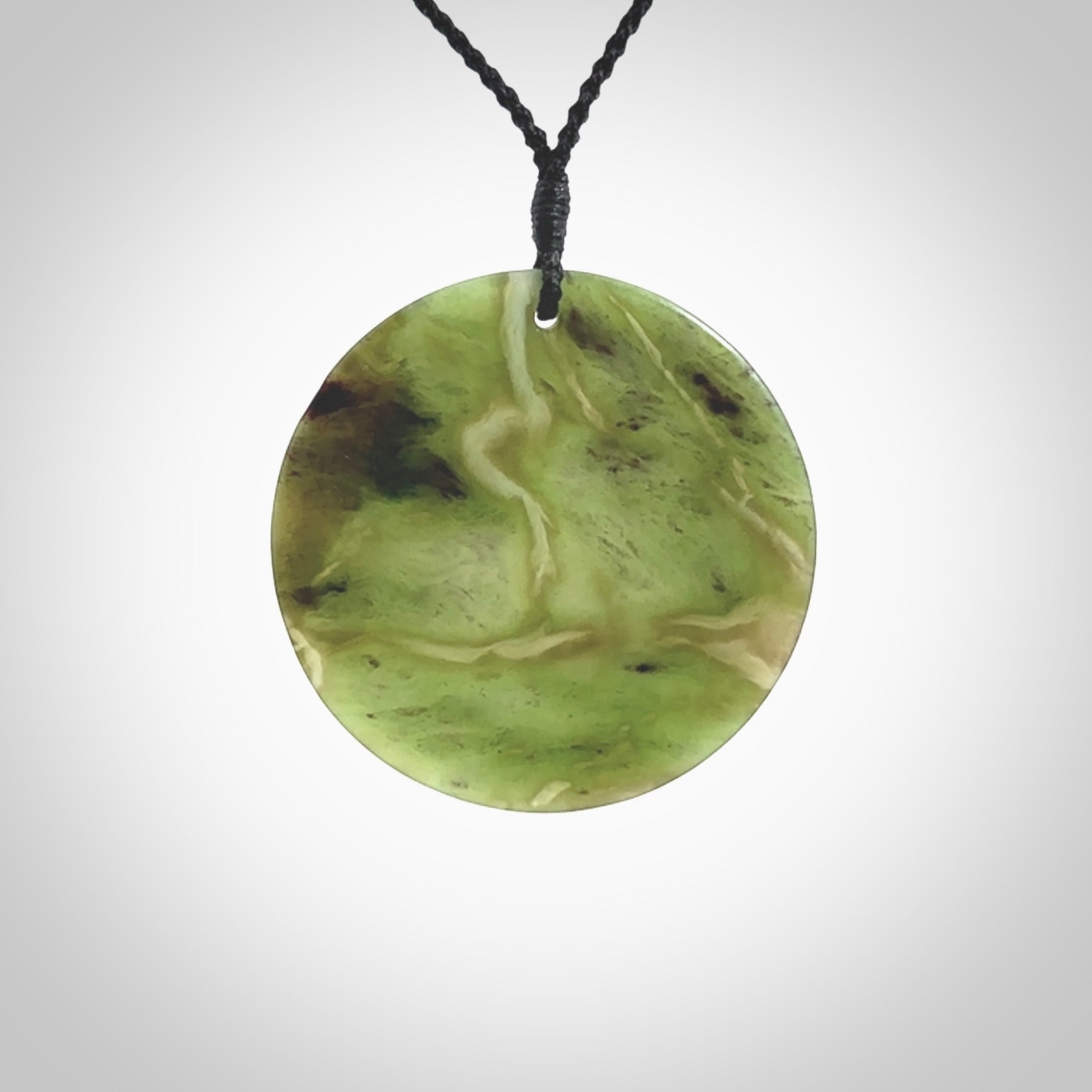 Hand carved New Zealand Totoweka Jade disc pendant by Ric Moor. Provided with black adjustable cord. Free worldwide delivery. One only pendant.