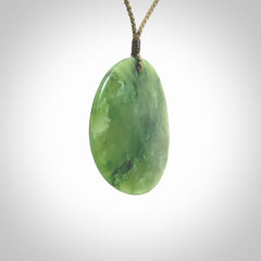 Hand carved New Zealand Jade disc pendant by Ric Moor. Provided with khaki adjustable cord. Free worldwide delivery. One only pendant.