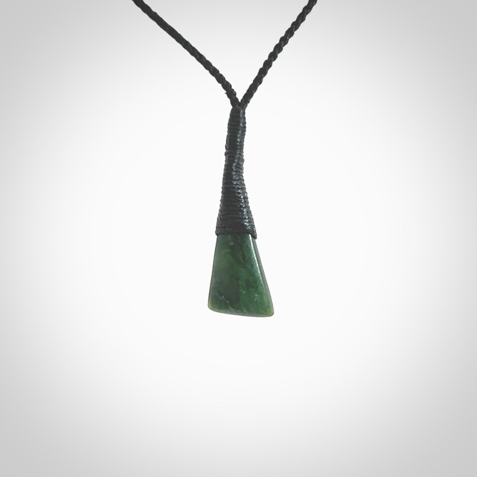 A lovely small sized New Zealand jade drop pendant. This piece is made from a wonderful deep green colour. Carved by Ric Moor for NZ Pacific and delivered worldwide. Provided with an adjustable black cord.