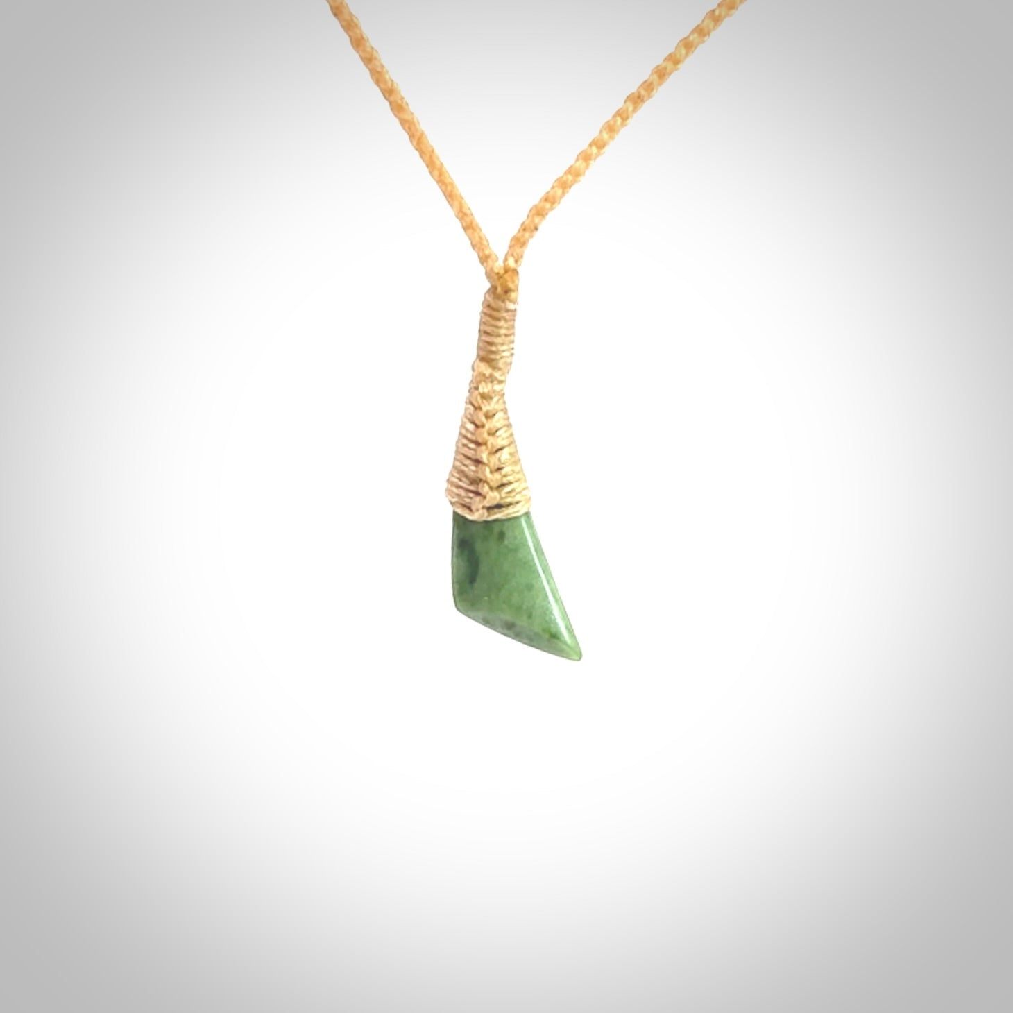 A lovely small sized New Zealand jade drop pendant. This piece is made from a light, green jade. Carved by Ric Moor for NZ Pacific and delivered worldwide. Delivered with adjustable beige cord.