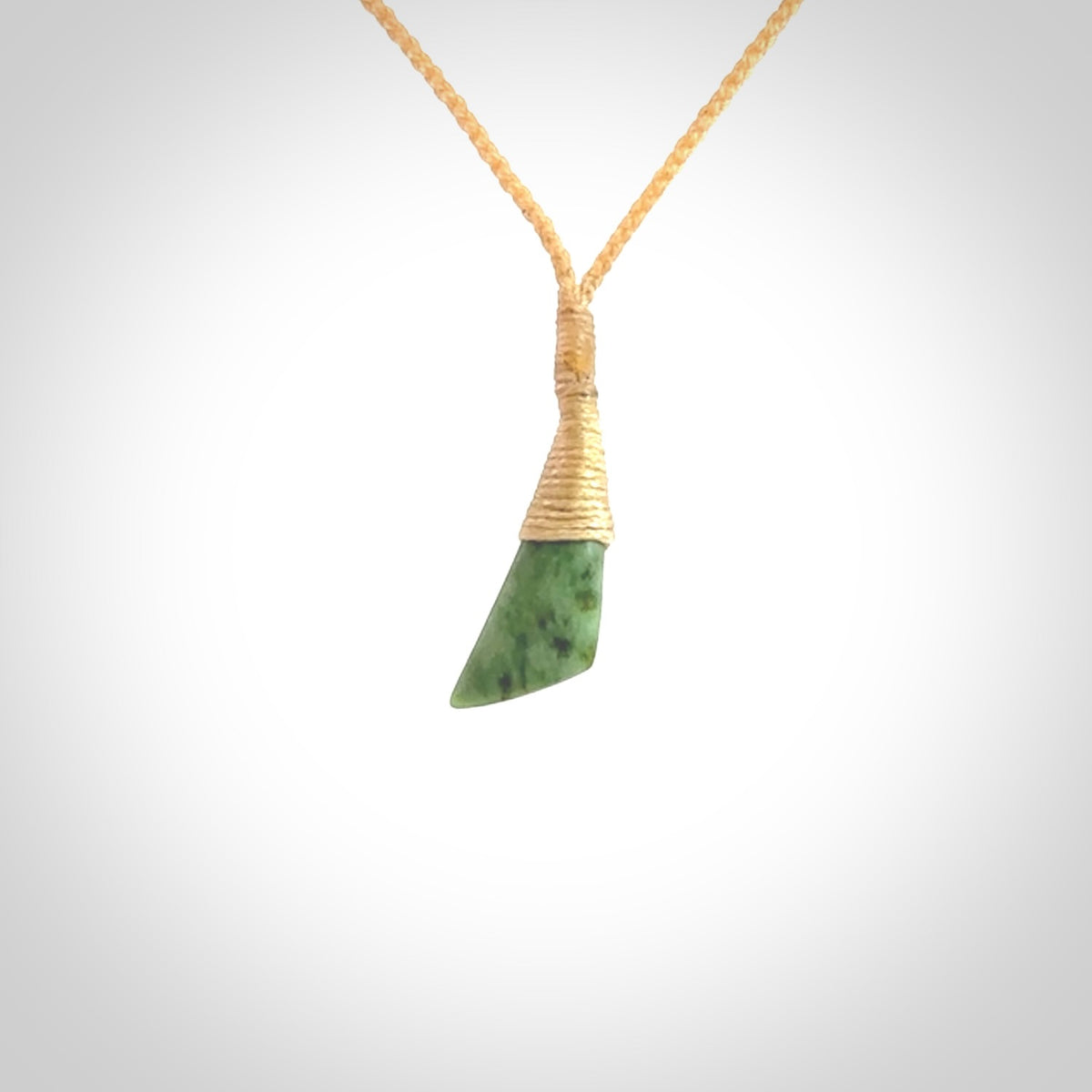 A lovely small sized New Zealand jade drop pendant. This piece is made from a light, green jade. Carved by Ric Moor for NZ Pacific and delivered worldwide. Delivered with adjustable beige cord.