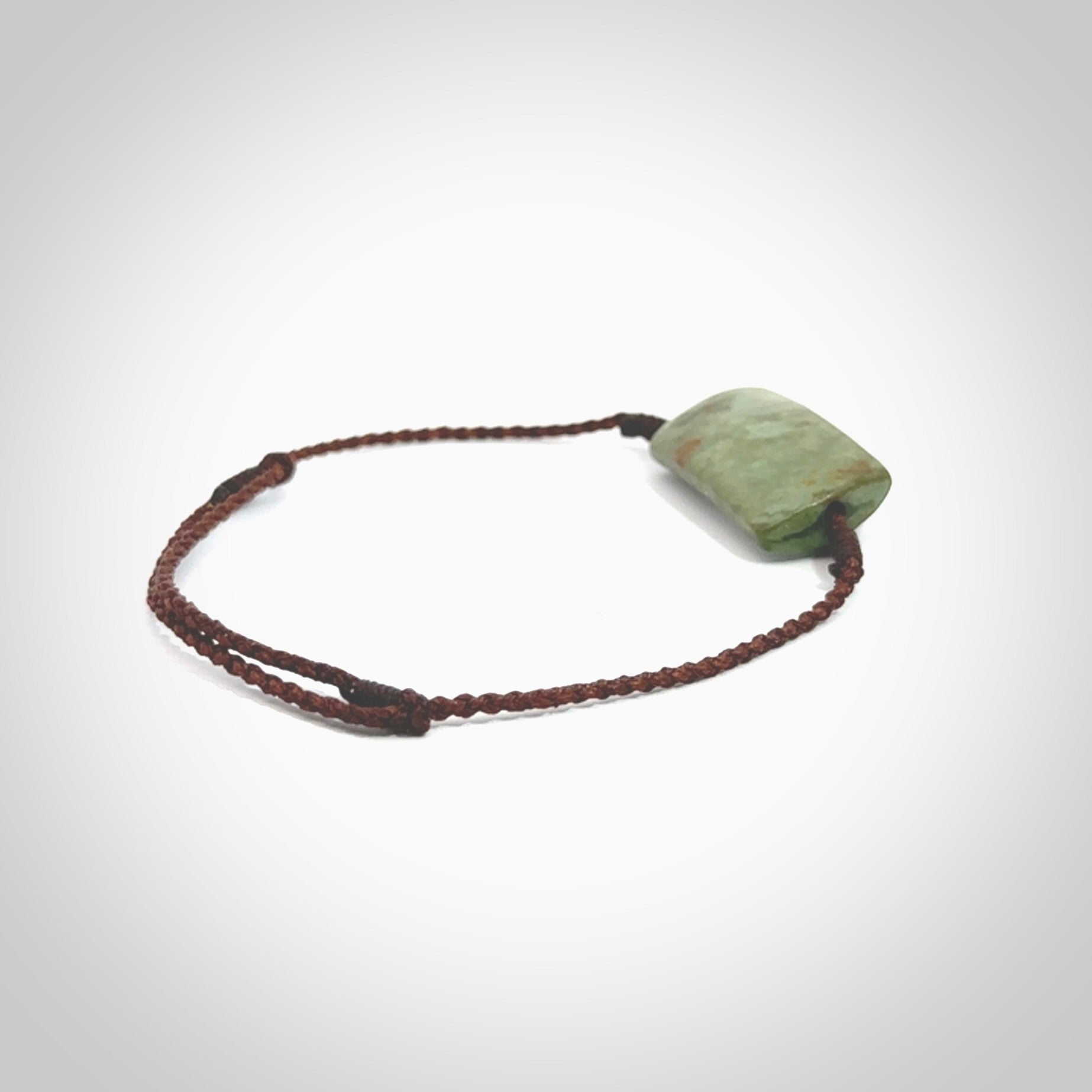 Hand carved New Zealand jade adjustable bracelet with brown cord. Carved in New Zealand jade by Ric Moor for NZ Pacific. One only adjustable armband for women and men.