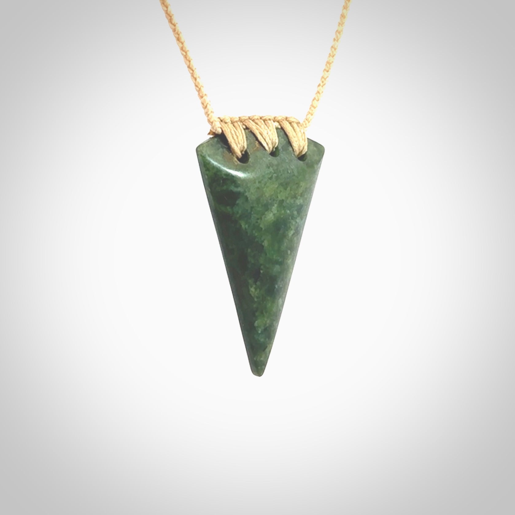 This photo shows a jade niho, drop shaped pendant. It a a lovely deep green jade. The cord is a four plait beige and is adjustable in length. One only medium, contemporary drop necklace from Jade, by Ric Moor.