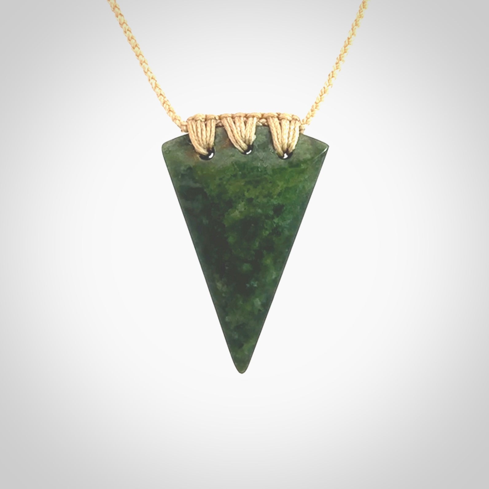 This photo shows a jade niho, drop shaped pendant. It a a lovely deep green jade. The cord is a four plait beige and is adjustable in length. One only medium, contemporary drop necklace from Jade, by Ric Moor.