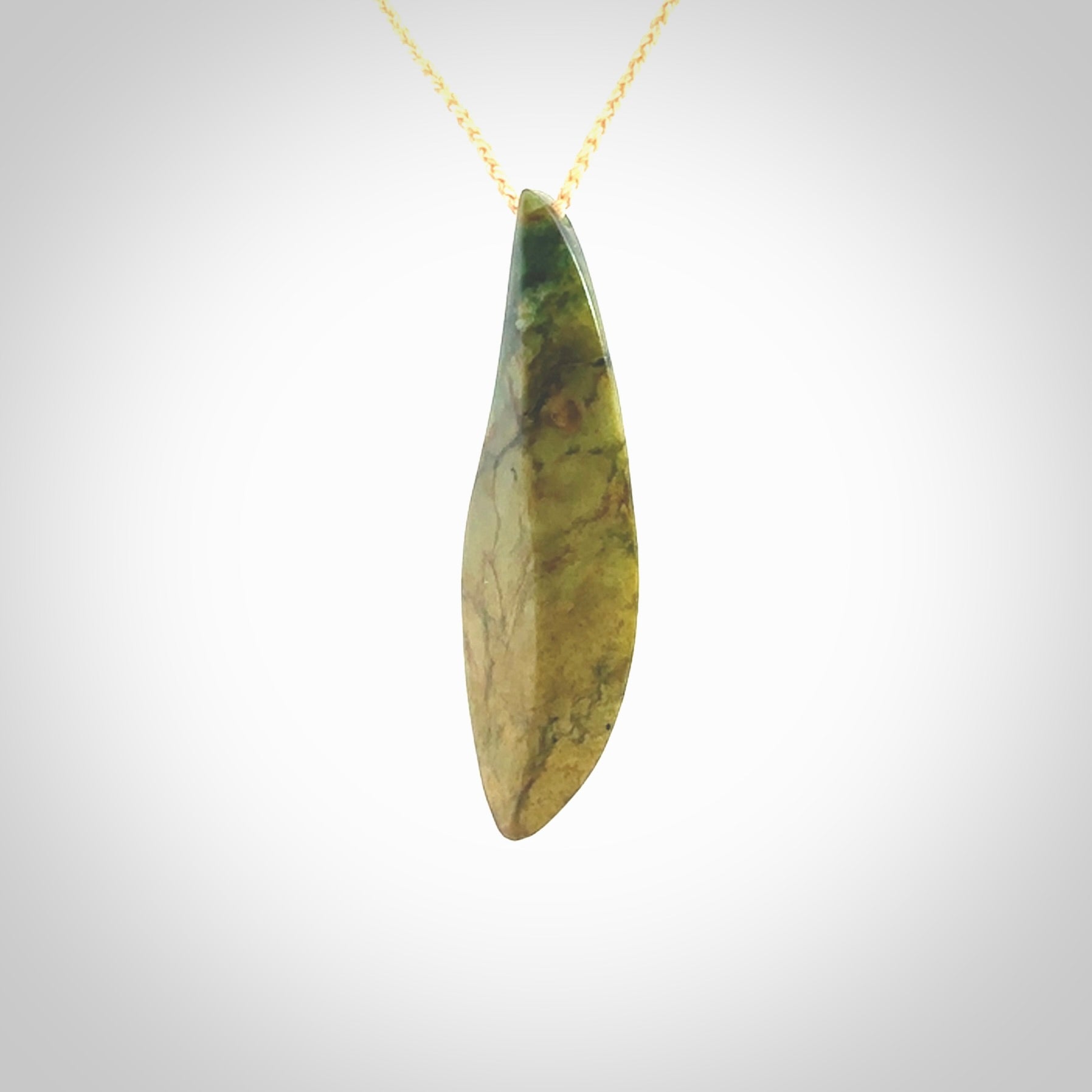 This photo shows a large flower jade drop shaped pendant. It a a lovely green and orange jade. The cord is a four plait beige and is adjustable in length. One only large, contemporary drop necklace from Jade, by Ric Moor.