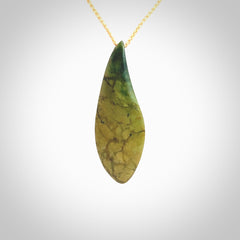 This photo shows a large flower jade drop shaped pendant. It a a lovely green and orange jade. The cord is a four plait beige and is adjustable in length. One only large, contemporary drop necklace from Jade, by Ric Moor.