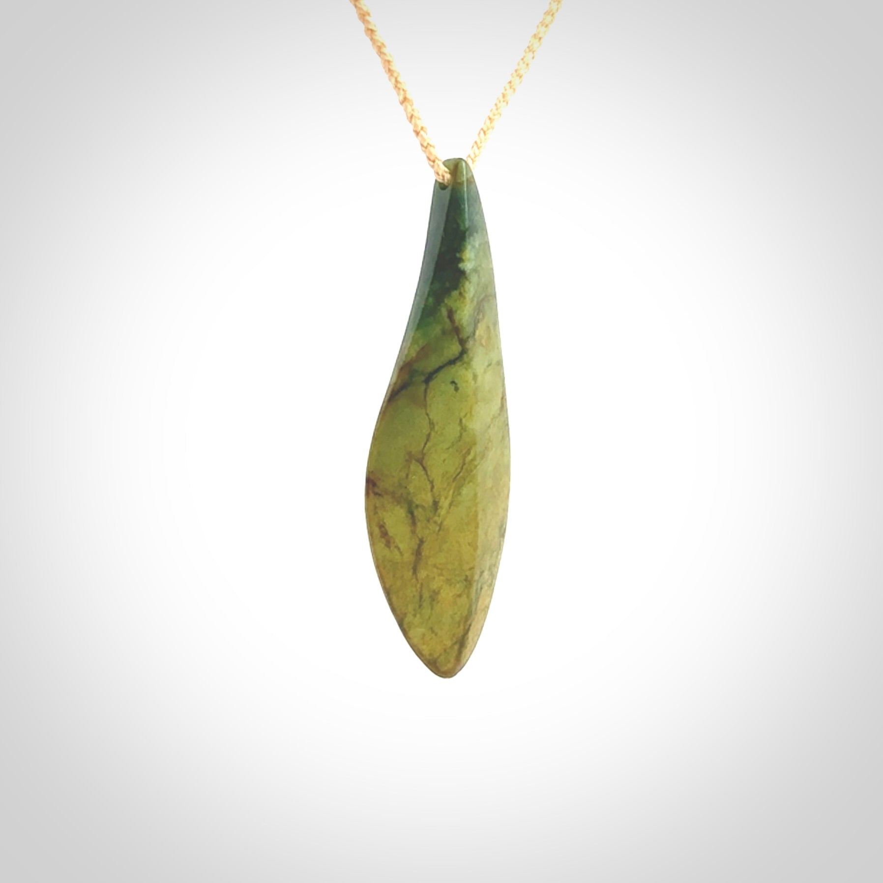 This photo shows a large flower jade drop shaped pendant. It a a lovely green and orange jade. The cord is a four plait beige and is adjustable in length. One only large, contemporary drop necklace from Jade, by Ric Moor.