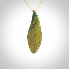 This photo shows a large flower jade drop shaped pendant. It a a lovely green and orange jade. The cord is a four plait beige and is adjustable in length. One only large, contemporary drop necklace from Jade, by Ric Moor.