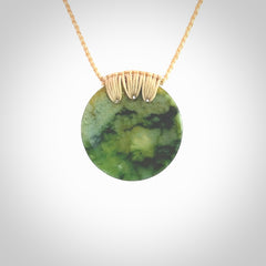 This piece is a medium sized cupped disc pendant. It was carved for us by Ric Moor from a lovely deep and milky green piece of New Zealand flower jade. It is suspended on a beige coloured braided cord that is length adjustable.