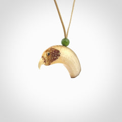 This is a hand carved deer antler bone kea bird head pendant. It is made from deer antler with jade bead. This is a medium sized necklace and is a very unique, one only, pendant that is a collectors piece. Hand carved by New Zealand artist, Sami. Provided with adjustable tan cord.