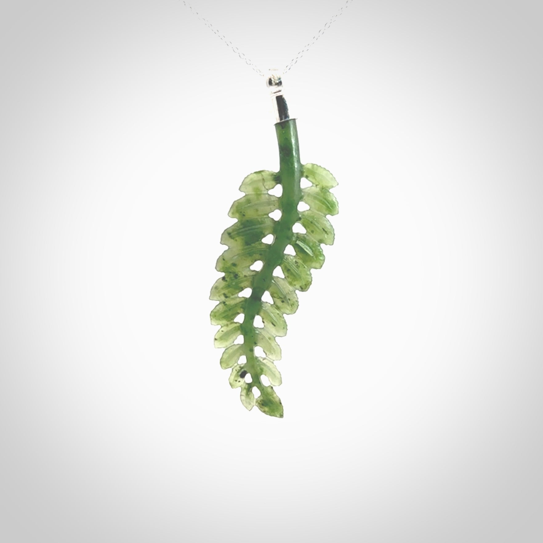 Fern Leaf Jade Stone pendant with Sterling Silver Cap. Handmade jade Fern Leaf jewellery made by NZ Pacific and for sale online. Jade stone Fern leaf pendant for men and women. Unique art to wear from NZ Pacific. Delivered on a Sterling Silver Chain.