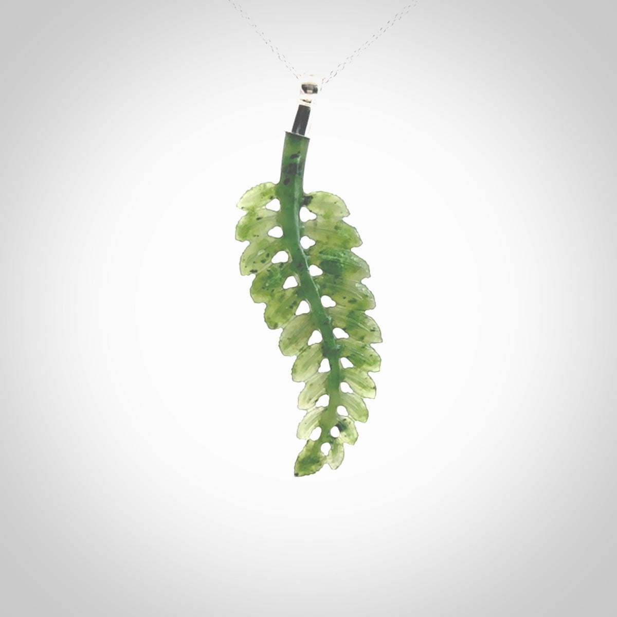 Fern Leaf Jade Stone pendant with Sterling Silver Cap. Handmade jade Fern Leaf jewellery made by NZ Pacific and for sale online. Jade stone Fern leaf pendant for men and women. Unique art to wear from NZ Pacific. Delivered on a Sterling Silver Chain.