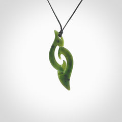 This photo shows a contemporary koru pendant carved from New Zealand Jade. The artist, Shaun Gardiner, has carved this beautifully. We provide this piece with an adjustable black cord. This is a fantastic work of art, we have one only.