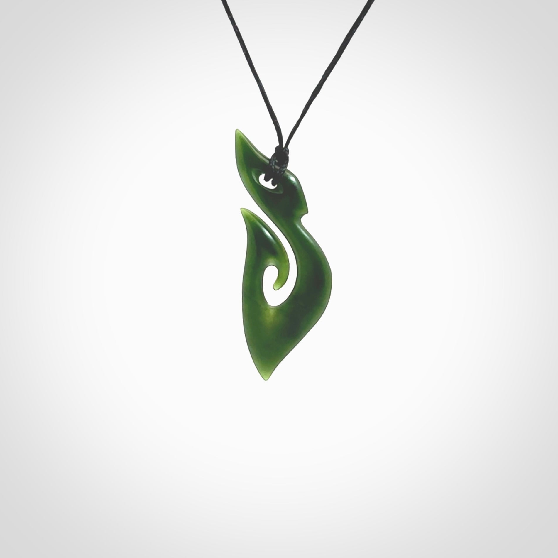 This photo shows a hook with koru pendant carved from New Zealand Jade. The artist, Shaun Gardiner, has carved this beautifully. We provide this piece with an adjustable black cord. This is a fantastic work of art, we have one only.