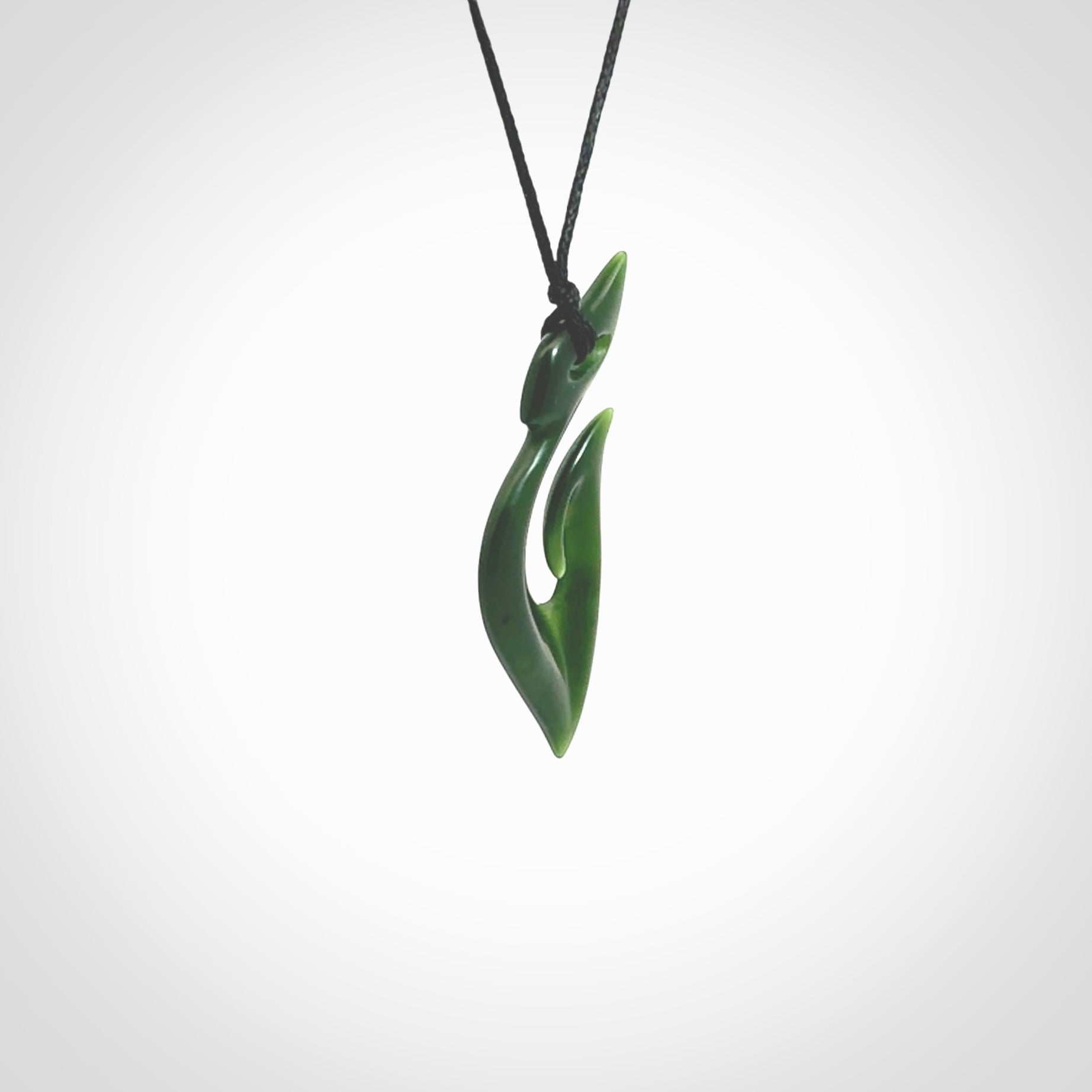 This photo shows a hook with koru pendant carved from New Zealand Jade. The artist, Shaun Gardiner, has carved this beautifully. We provide this piece with an adjustable black cord. This is a fantastic work of art, we have one only.