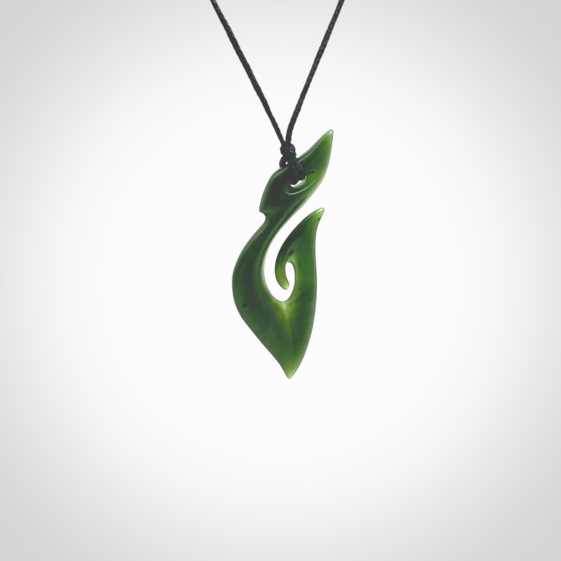 This photo shows a hook with koru pendant carved from New Zealand Jade. The artist, Shaun Gardiner, has carved this beautifully. We provide this piece with an adjustable black cord. This is a fantastic work of art, we have one only.