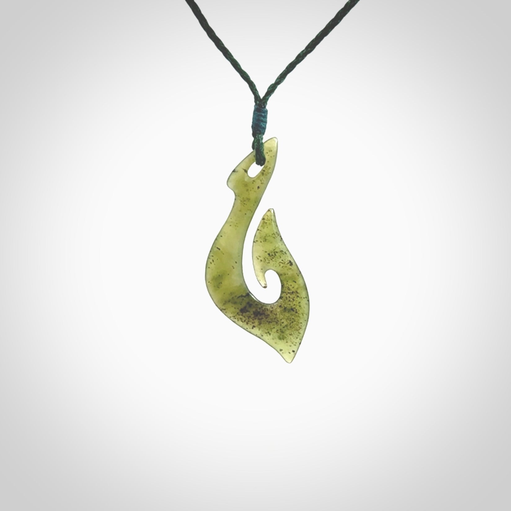 This photo shows a matau pendant carved from New Zealand Kawakawa Jade. The artist, Shaun Gardiner, has carved this beautifully. We provide this piece with an adjustable green coloured cord. This is a fantastic work of art, we have one only.