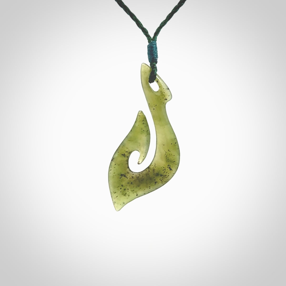 This photo shows a matau pendant carved from New Zealand Kawakawa Jade. The artist, Shaun Gardiner, has carved this beautifully. We provide this piece with an adjustable green coloured cord. This is a fantastic work of art, we have one only.