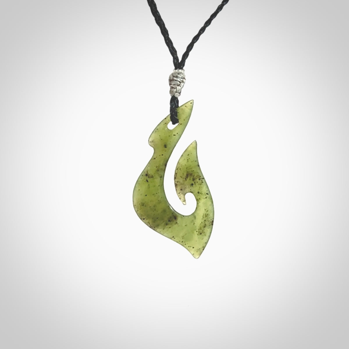 This photo shows a matau pendant carved from New Zealand Kawakawa Jade. The artist, Shaun Gardiner, has carved this beautifully. We provide this piece with an adjustable black coloured cord. This is a fantastic work of art, we have one only.