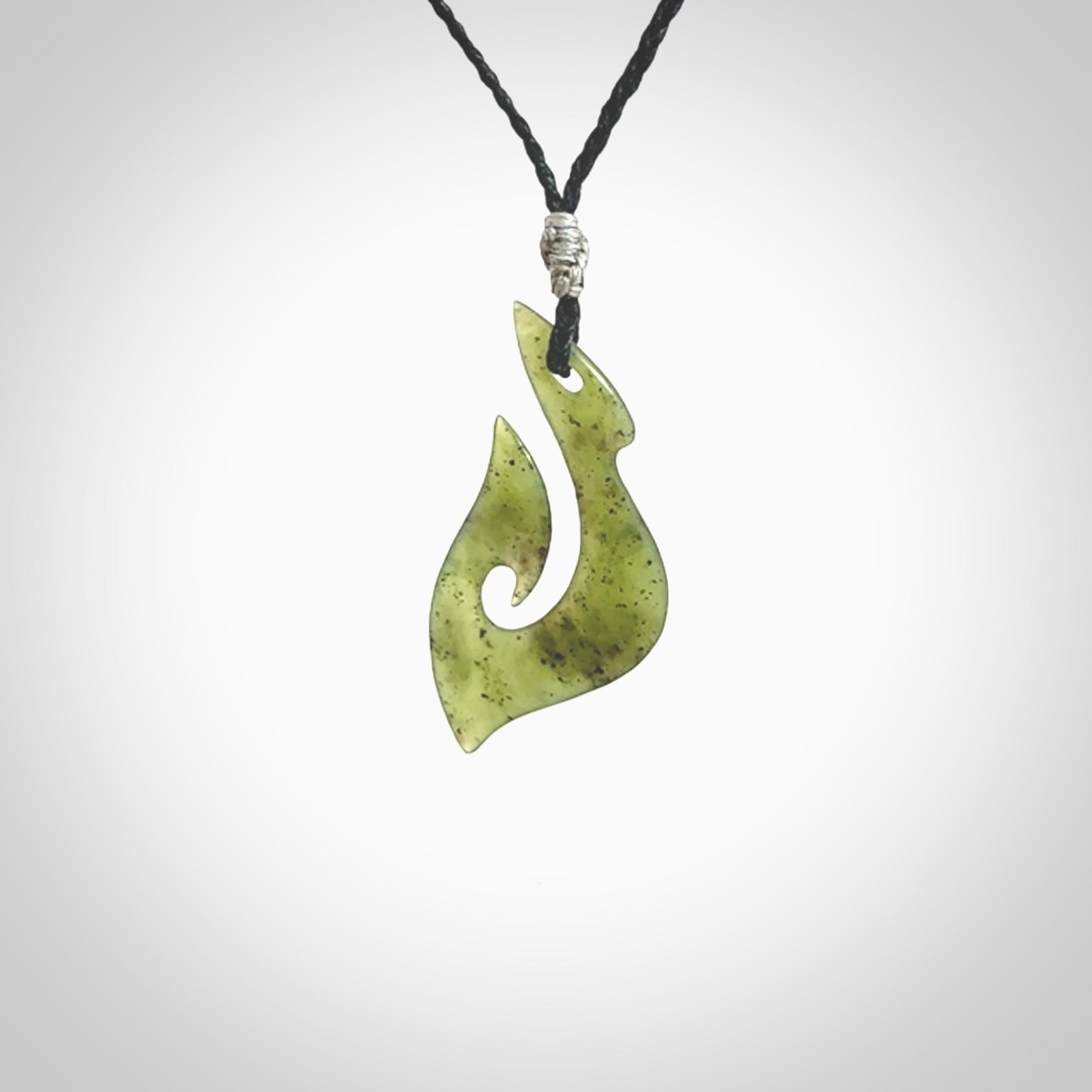 This photo shows a matau pendant carved from New Zealand Kawakawa Jade. The artist, Shaun Gardiner, has carved this beautifully. We provide this piece with an adjustable black coloured cord. This is a fantastic work of art, we have one only.