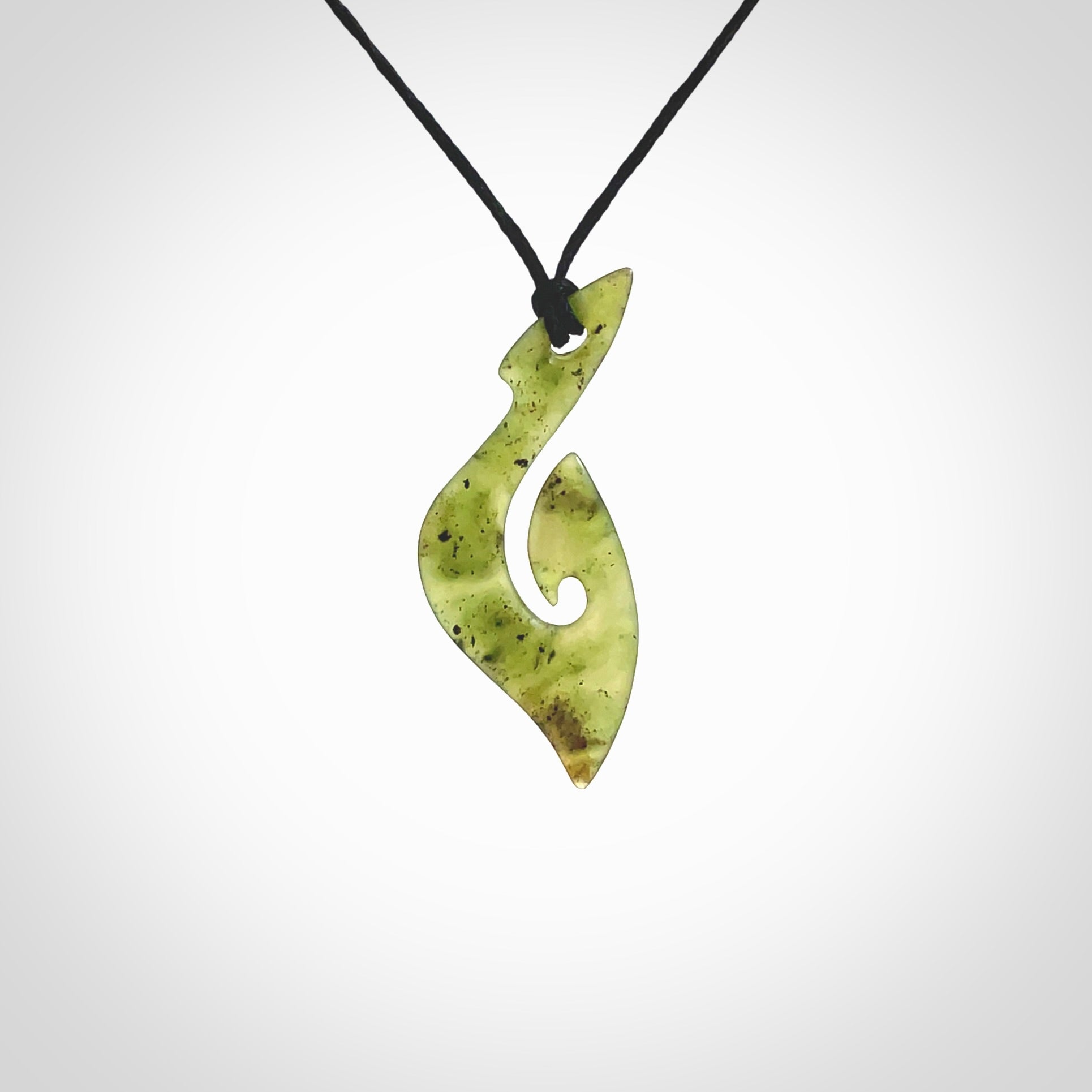 This photo shows a matau pendant carved from New Zealand Jade. The artist, Shaun Gardiner, has carved this beautifully. We provide this piece with an adjustable black coloured cord. This is a fantastic work of art, we have one only.