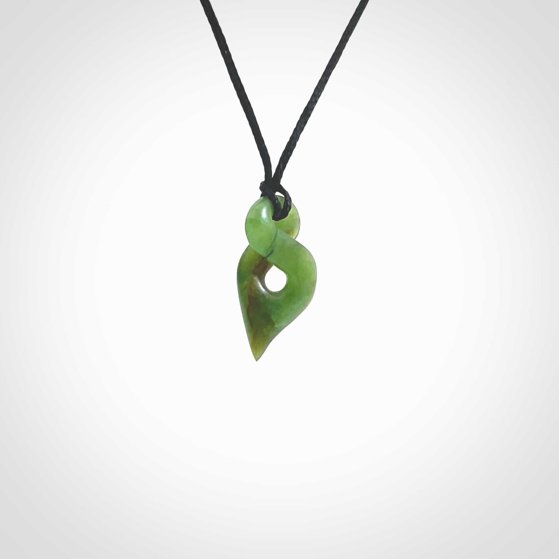 Hand carved small sized, New Zealand jade twist pendant. Carved in New Zealand by NZ Pacific. Hand made small Jade twist with adjustable black cord by Shaun Gardiner.