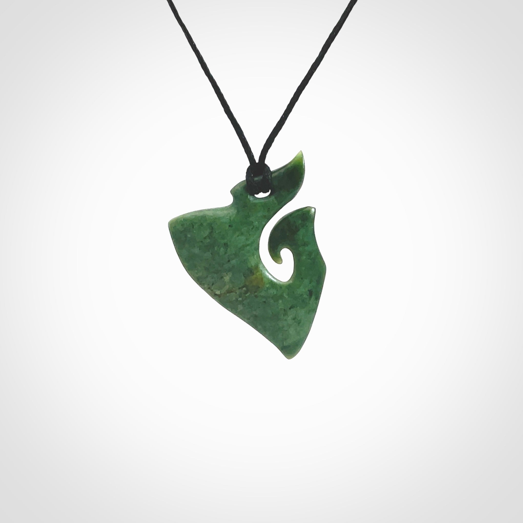 This photo shows a small koru pendant carved from New Zealand Jade. The artist, Shaun Gardiner, has carved this beautifully. We provide this piece with an adjustable Black cord. This is a fantastic work of art, we have one only.