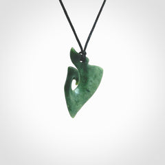 This photo shows a small koru pendant carved from New Zealand Jade. The artist, Shaun Gardiner, has carved this beautifully. We provide this piece with an adjustable Black cord. This is a fantastic work of art, we have one only.