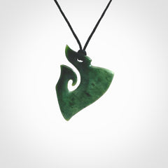 This photo shows a small koru pendant carved from New Zealand Jade. The artist, Shaun Gardiner, has carved this beautifully. We provide this piece with an adjustable Black cord. This is a fantastic work of art, we have one only.