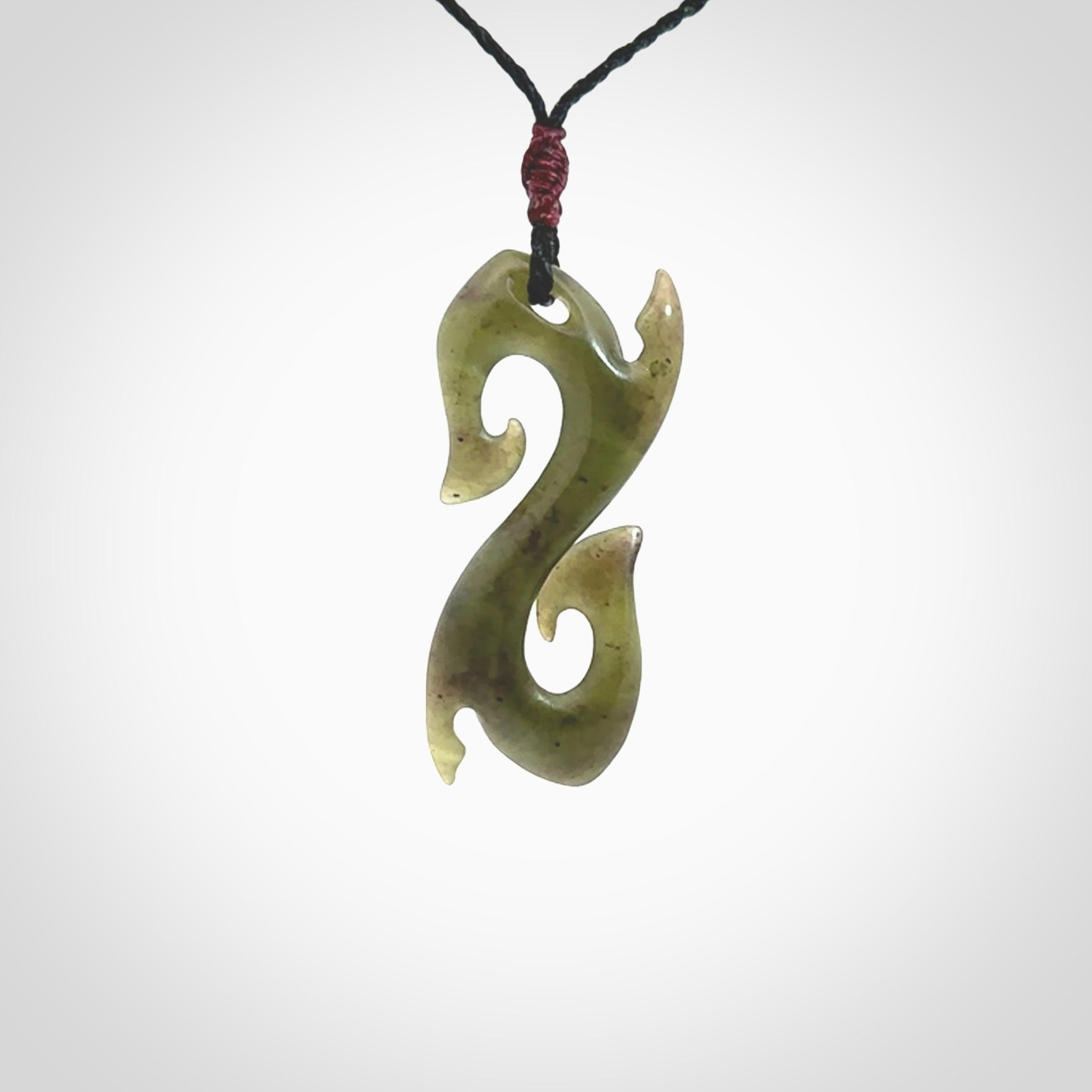 This photo shows a contemporary S shaped pendant carved from New Zealand Jade. The artist, Shaun Gardiner, has carved this beautifully. We provide this piece with an adjustable black cord. This is a fantastic work of art, we have one only.