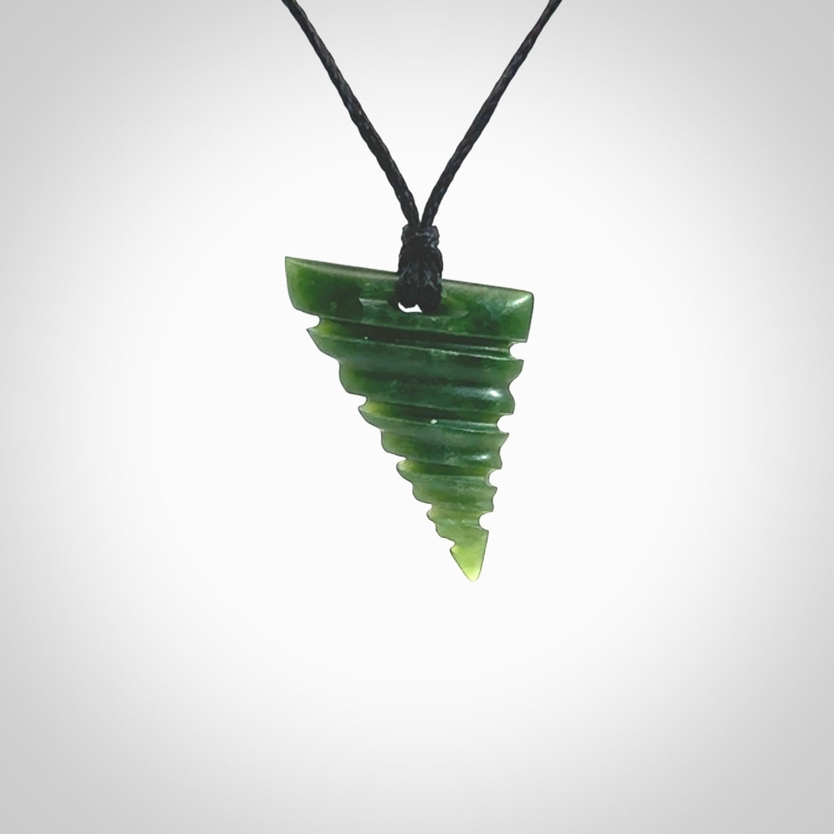 This photo shows a contemporary drop carved into New Zealand Jade. The artist, Shaun Gardiner, has carved this beautifully. We have added an adjustable black cord. This is a fantastic work of art, we have one only.