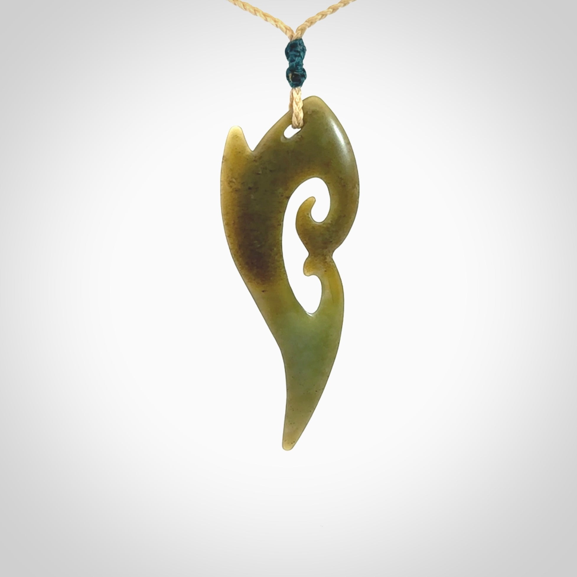 This photo shows a koru pendant carved from New Zealand Jade. The artist, Shaun Gardiner, has carved this beautifully. We provide this piece with an adjustable oat coloured cord. This is a fantastic work of art, we have one only.