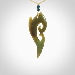 This photo shows a koru pendant carved from New Zealand Jade. The artist, Shaun Gardiner, has carved this beautifully. We provide this piece with an adjustable oat coloured cord. This is a fantastic work of art, we have one only.