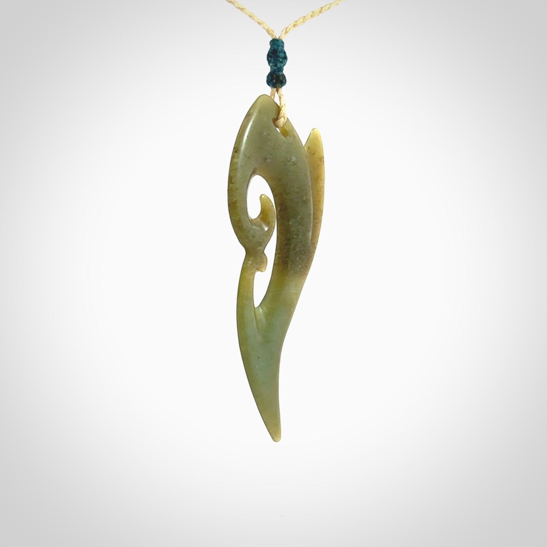 This photo shows a koru pendant carved from New Zealand Jade. The artist, Shaun Gardiner, has carved this beautifully. We provide this piece with an adjustable oat coloured cord. This is a fantastic work of art, we have one only.