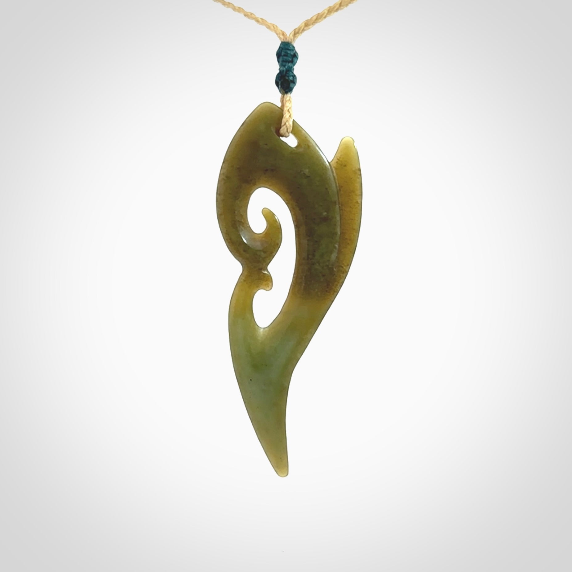 This photo shows a koru pendant carved from New Zealand Jade. The artist, Shaun Gardiner, has carved this beautifully. We provide this piece with an adjustable oat coloured cord. This is a fantastic work of art, we have one only.