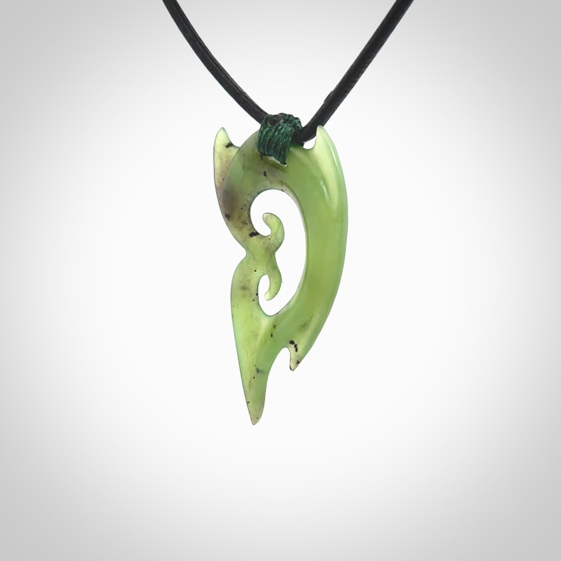 This photo shows a large contemporary double koru pendant carved from New Zealand Jade. The artist, Shaun Gardiner, has carved this beautifully. We provide this piece with a fixed length black leather cord. This is a fantastic work of art, we have one only.