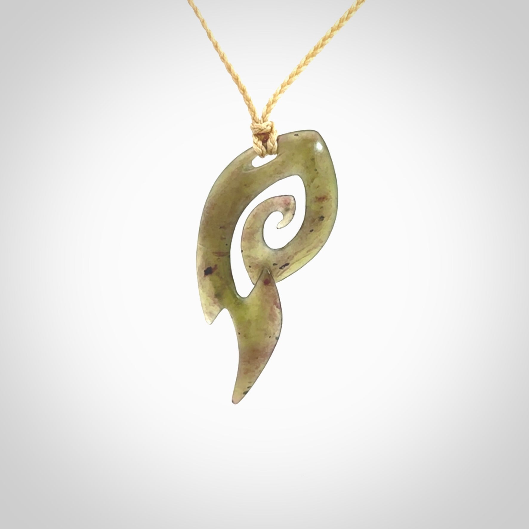 This photo shows a contemporary koru pendant carved from New Zealand Jade. The artist, Shaun Gardiner, has carved this beautifully. We provide this piece with an adjustable oat coloured cord. This is a fantastic work of art, we have one only.