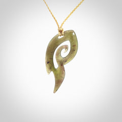 This photo shows a contemporary koru pendant carved from New Zealand Jade. The artist, Shaun Gardiner, has carved this beautifully. We provide this piece with an adjustable oat coloured cord. This is a fantastic work of art, we have one only.