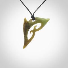 This photo shows a contemporary koru pendant carved from New Zealand Jade. The artist, Shaun Gardiner, has carved this beautifully. We provide this piece with an adjustable black coloured cord. This is a fantastic work of art, we have one only.