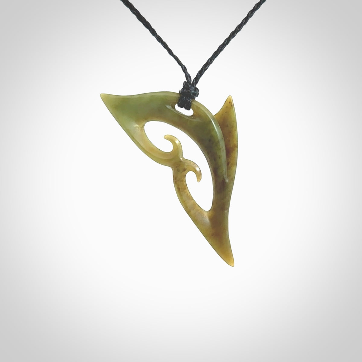 This photo shows a contemporary koru pendant carved from New Zealand Jade. The artist, Shaun Gardiner, has carved this beautifully. We provide this piece with an adjustable black coloured cord. This is a fantastic work of art, we have one only.