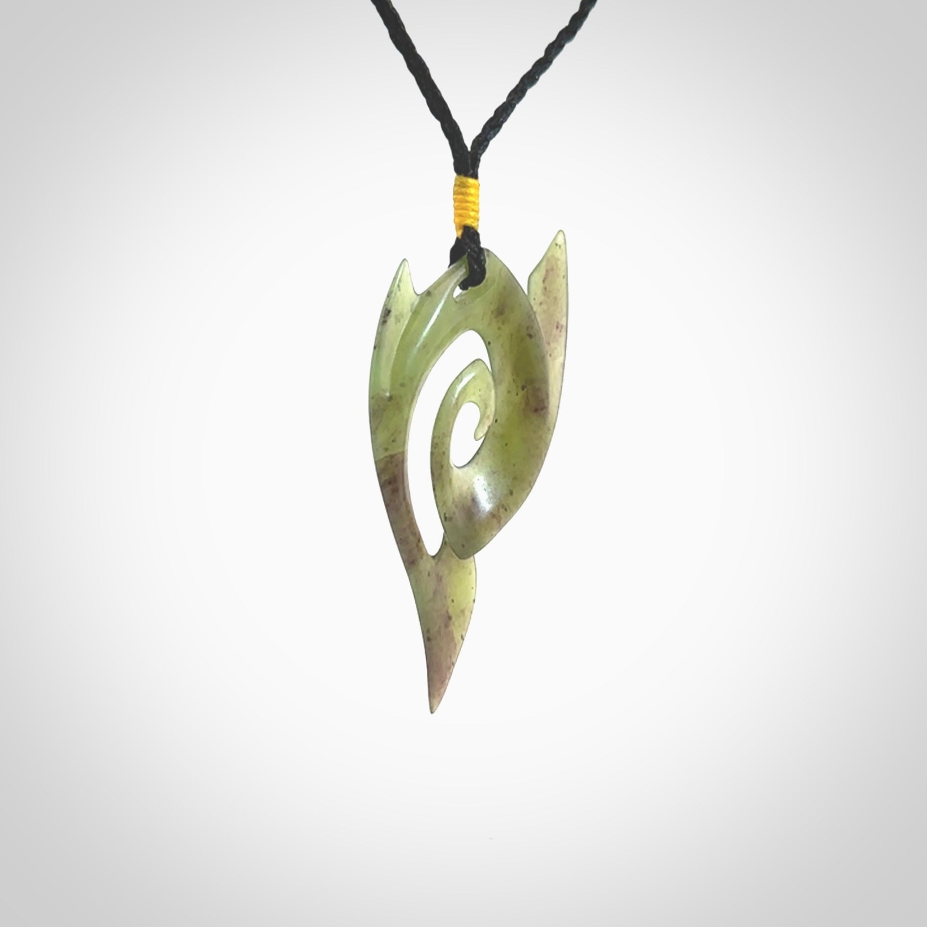 This photo shows a contemporary koru pendant carved from New Zealand Jade. The artist, Shaun Gardiner, has carved this beautifully. We provide this piece with an adjustable black coloured cord. This is a fantastic work of art, we have one only.