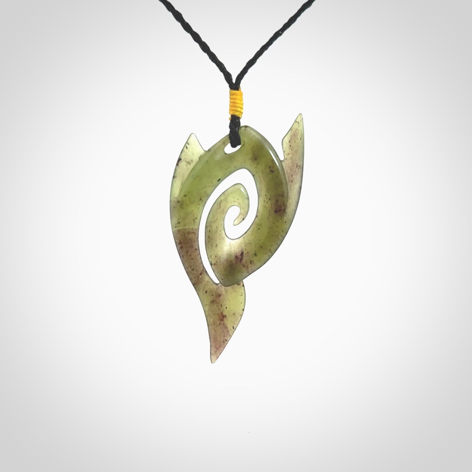 This photo shows a contemporary koru pendant carved from New Zealand Jade. The artist, Shaun Gardiner, has carved this beautifully. We provide this piece with an adjustable black coloured cord. This is a fantastic work of art, we have one only.