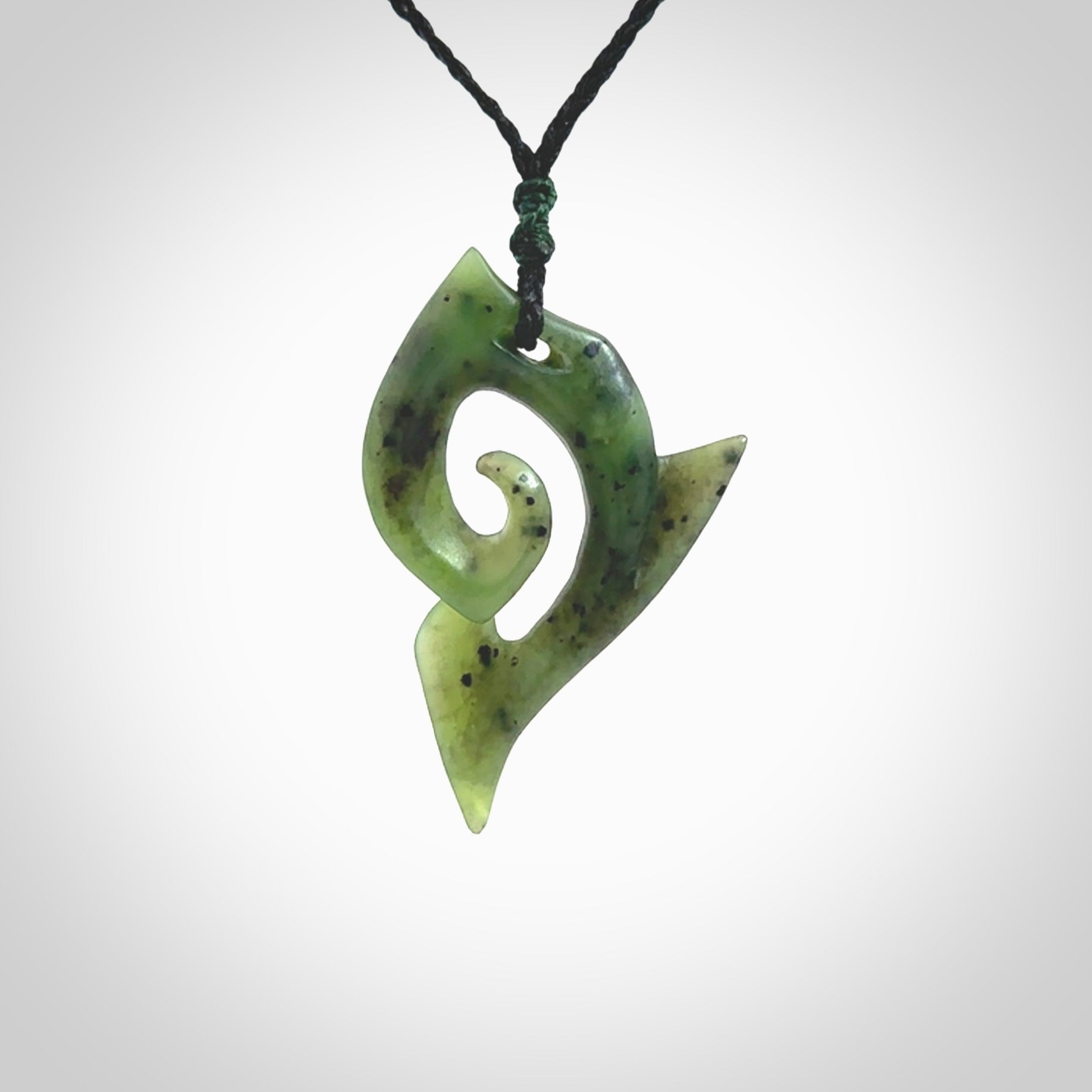 This photo shows a koru pendant carved from New Zealand Jade. The artist, Shaun Gardiner, has carved this beautifully. We provide this piece with an adjustable olive black cord. This is a fantastic work of art, we have one only.