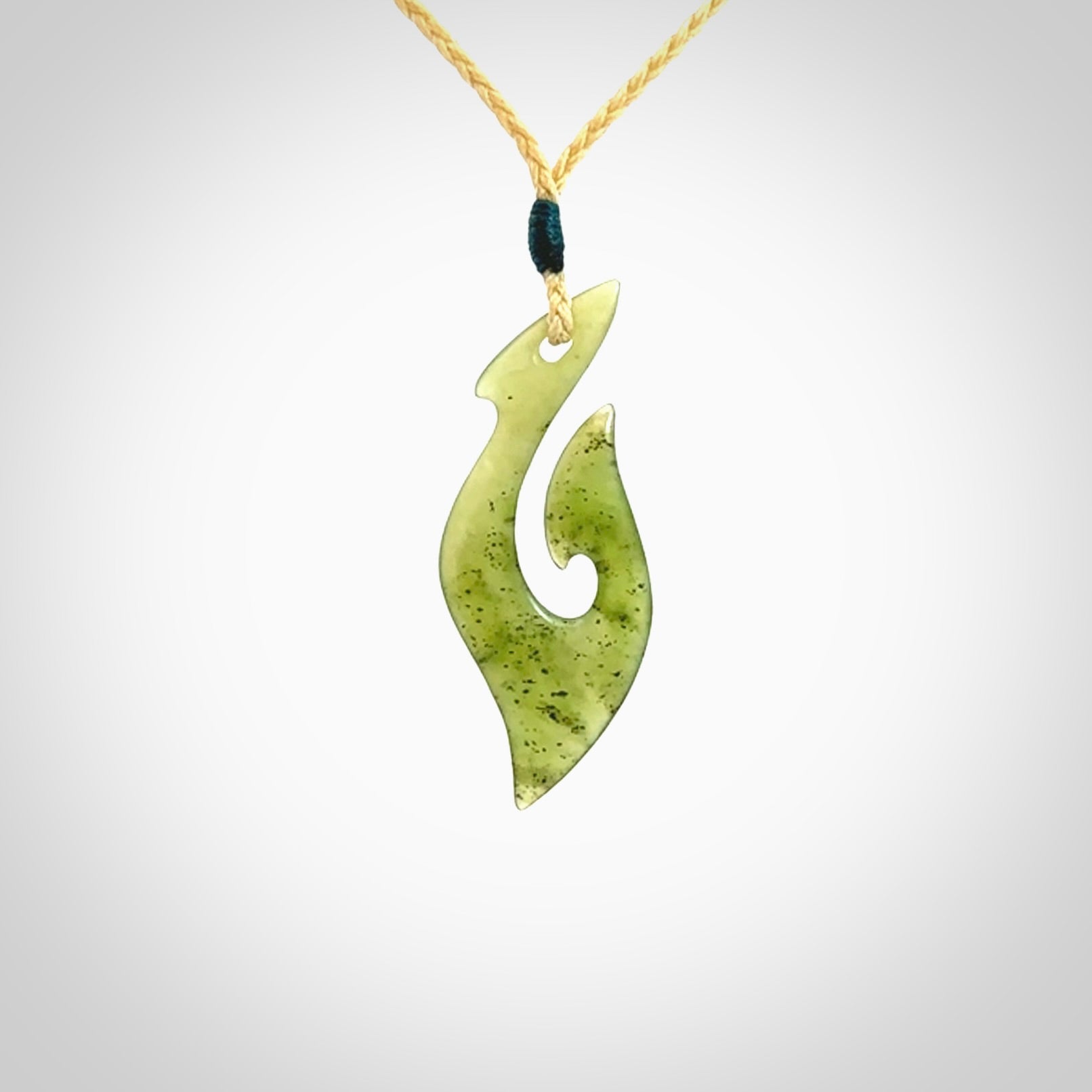 This photo shows a matau pendant carved from New Zealand Kawakawa Jade. The artist, Shaun Gardiner, has carved this beautifully. We provide this piece with an adjustable oat coloured cord. This is a fantastic work of art, we have one only.