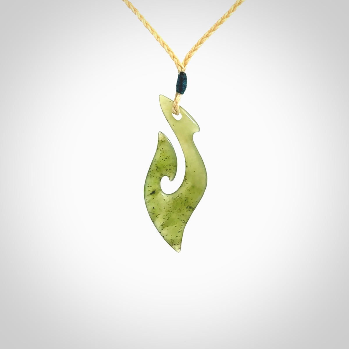 This photo shows a matau pendant carved from New Zealand Kawakawa Jade. The artist, Shaun Gardiner, has carved this beautifully. We provide this piece with an adjustable oat coloured cord. This is a fantastic work of art, we have one only.