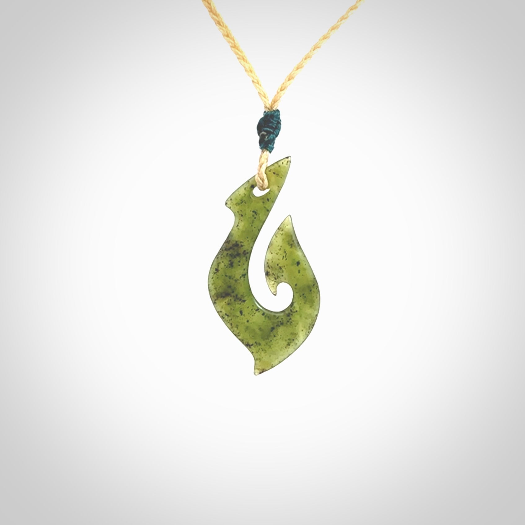 This photo shows a matau pendant carved from New Zealand Jade. The artist, Shaun Gardiner, has carved this beautifully. We provide this piece with an adjustable oat coloured cord. This is a fantastic work of art, we have one only.