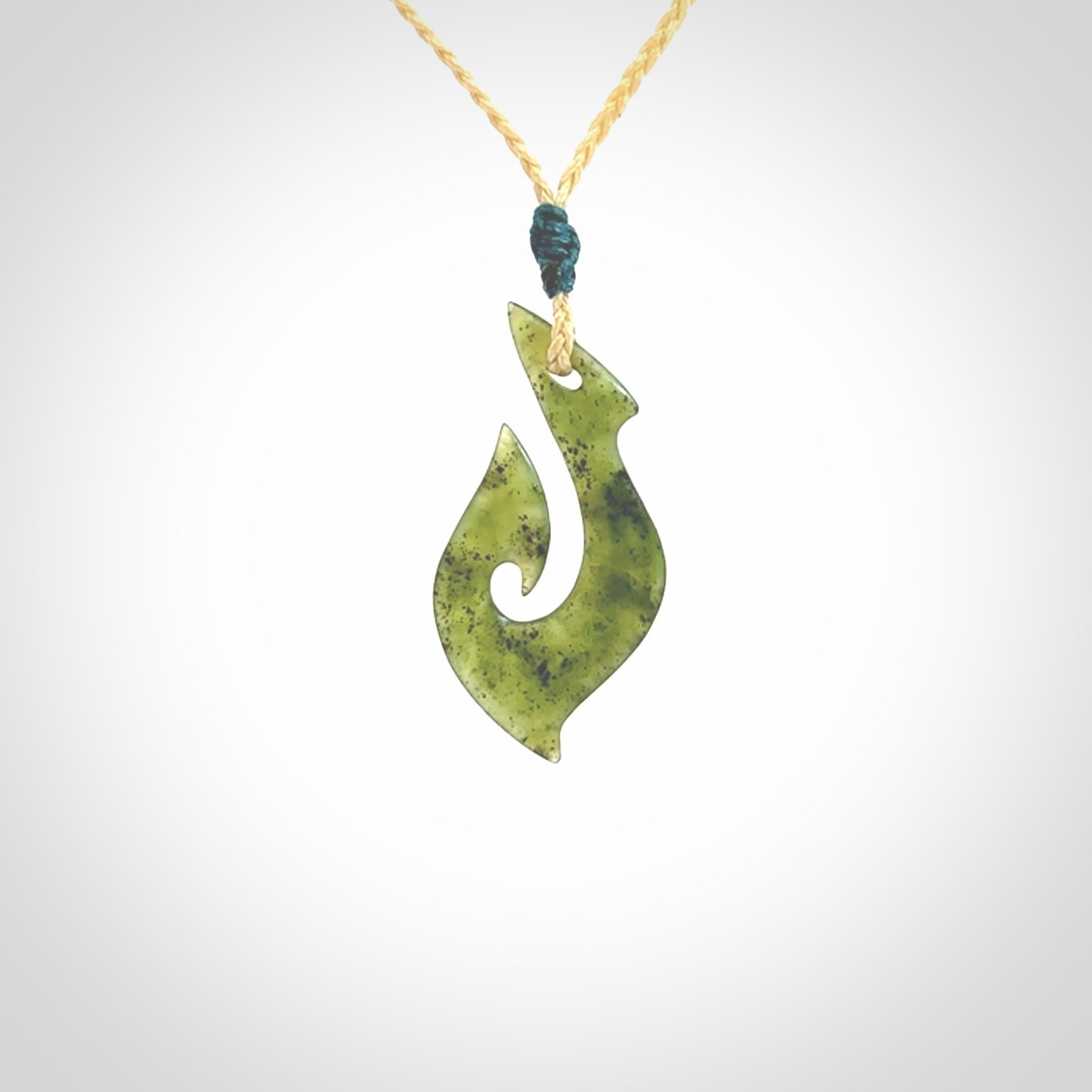 This photo shows a matau pendant carved from New Zealand Jade. The artist, Shaun Gardiner, has carved this beautifully. We provide this piece with an adjustable oat coloured cord. This is a fantastic work of art, we have one only.